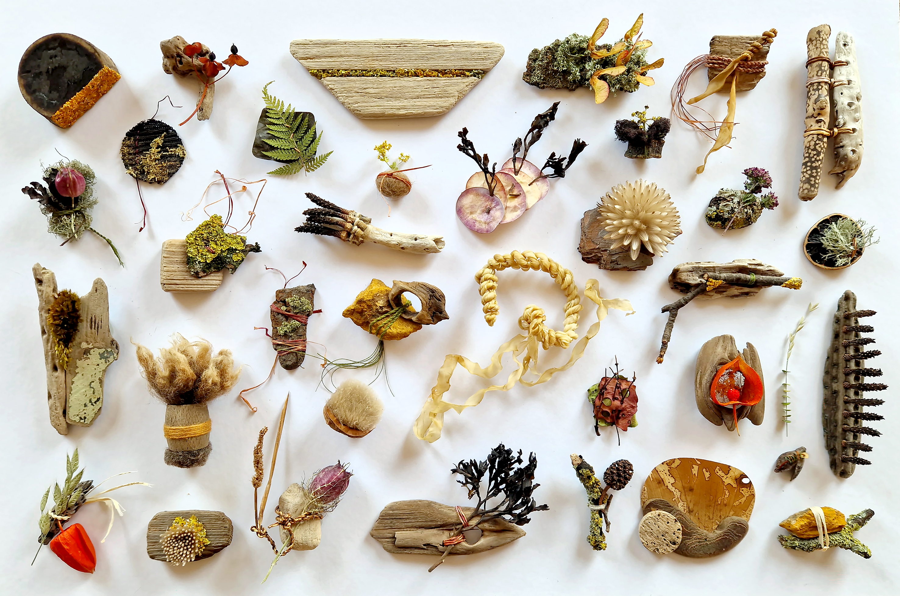 Mosslings made from natural materials, arranged on a white surface